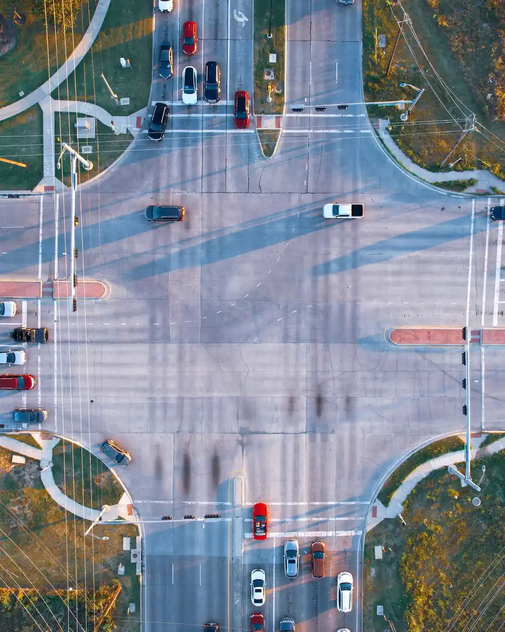 Overhead view of vehicles moving through a wide signalized intersection