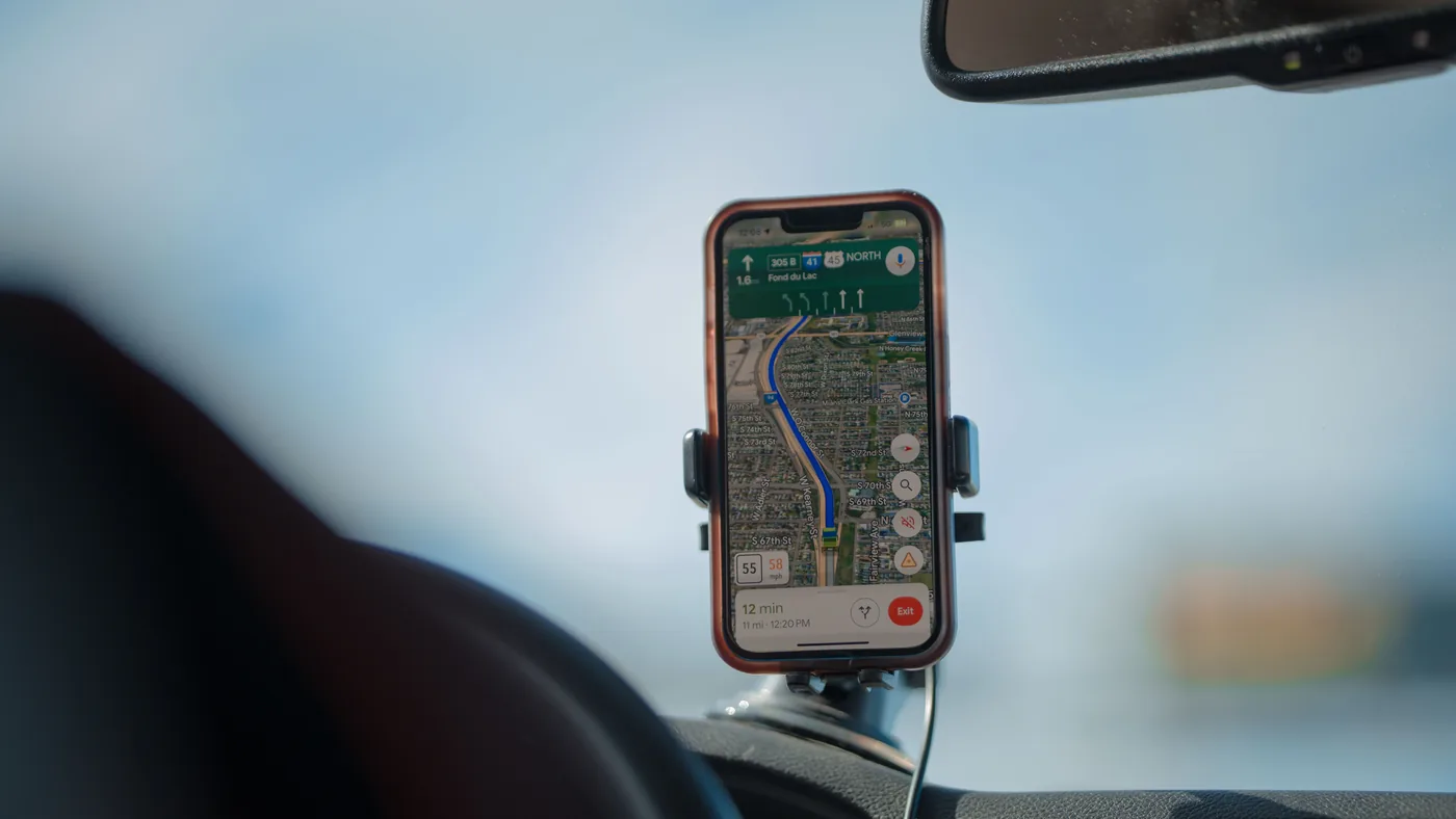 Smartphone showing turn-by-turn navigation, mounted on a car windshield