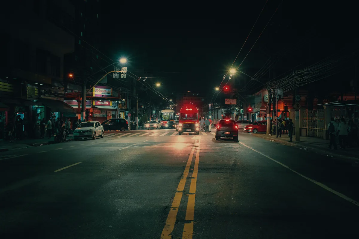 Emergency vehicle and traffic moving along a city street at night